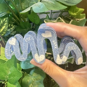 Blue denim texture hair claw clip with heart patterns and lucky text on green leaves
