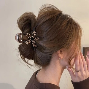 Elegant leopard print flower hair claw clip securing a low bun hairstyle for women
