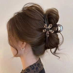 Elegant leopard print flower hair claw clip securing a stylish bun hairstyle for women