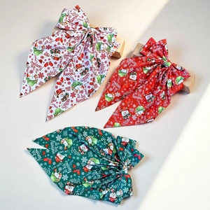 Three-color Christmas hair bows with snowman and snowflake prints on a wooden base
