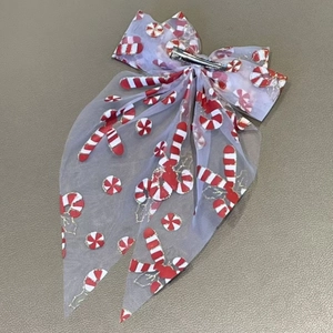 Detail showing the silver metal alligator clip and festive mesh bow with candy cane patterns