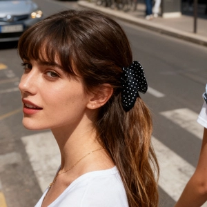 Dettaglio dell'elegante molletta per capelli a pois bianchi e neri su stile casual