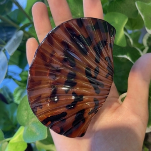 Elegant leopard shell claw clip in tortoiseshell resin held for size demonstration