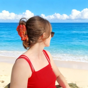 Vibrant translucent red lobster hair claw clip on a ponytail against a sunny beach backdrop