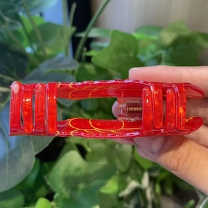 Translucent red lobster claw clip with yellow ring patterns for hair styling