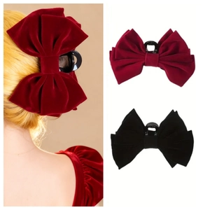 Macro detail of large velvet bow hair claw clip in elegant burgundy and black colors