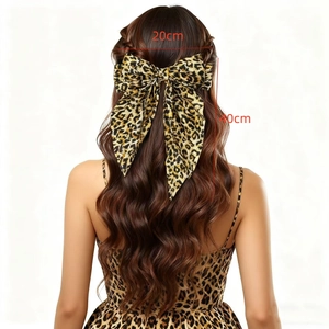 Large leopard print bow hair clip with long ribbons worn by a model on back view