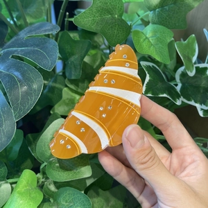 Dettaglio ravvicinato della pinza per capelli a forma di croissant con piccoli strass