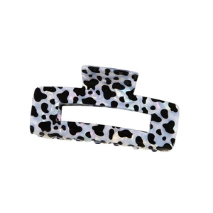 Détail de la pince à cheveux léopard blanc avec fini nacré et design rectangulaire