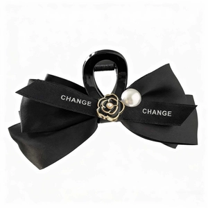 Elegant black camellia bow hair claw clip with pearl accents and satin ribbon
