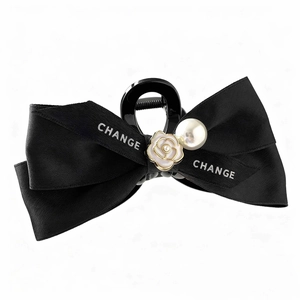 Elegant black camellia bow hair claw clip with pearl accent and white floral detail