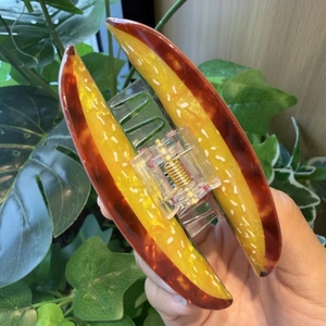 Close-up of hot dog food shaped hair claw clip with yellow resin and metal spring