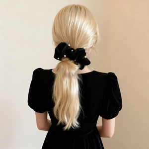 Elegant black velvet scrunchie with white pearls shown on blonde hair tied in a ponytail