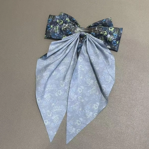 Détail de la pince métallique au dos du nœud à motif football avec longs rubans