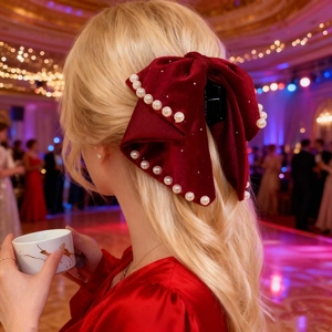 Large red velvet bow hair claw with pearls for elegant Christmas party hairstyles