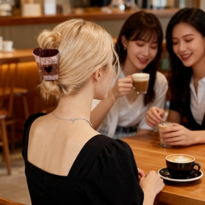 Creative coffee cup hair claw clip with pink marble texture on a blonde model's hair bun
