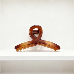 Detail of 13cm matte amber claw clip with tortoiseshell pattern and secure grip teeth
