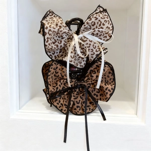 Detailed view of leopard print bow hair claws with elegant hanging ribbon tassels