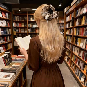 Leopard print scrunchie with white ribbon detail worn on hair in library setting