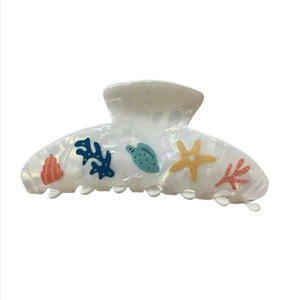 Detail of white ocean-themed hair claw clip with colorful starfish and fish patterns