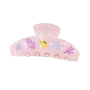 Close-up of translucent pink ocean-themed hair claw with coral and starfish patterns