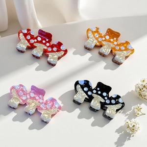 Detail of colorful mushroom hair claws with white polka dots and pearlescent finish