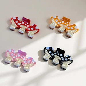 Detailed view of colorful mushroom hair claws with white polka dots in four various shades