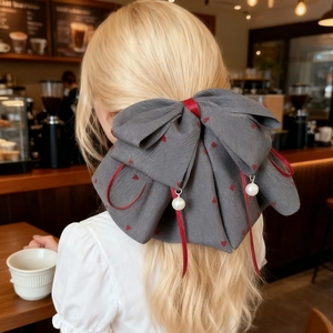 Pince à cheveux nœud français à pois cœur rouge et perles pendantes dans un café