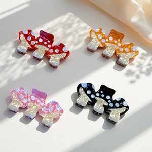 Detailed top view of mushroom hair claws in red, orange, pink and black marble acetate