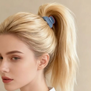 Close-up of a blue denim hair claw clip with red piping used for a high ponytail style
