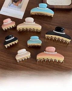 Detail view of pearl-embellished acetate hair claws in various sizes and colors
