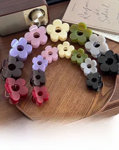 Detailed close-up of elegant flower hair claws in multiple colors on a vintage wooden tray