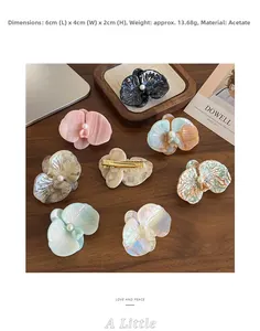 Dettaglio di fermagli per capelli a orchidea in acetato con perle su base in legno vero