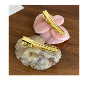 Dettaglio di fermagli per capelli a orchidea rosa e viola con clip in metallo dorato