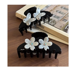 Dettaglio di fermagli per capelli vintage con decorazioni di fiori e farfalle