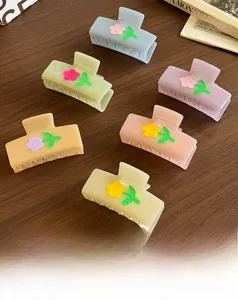 Detailed set of 6 colorful acetate flower hair claws in macaron tones on a wooden surface