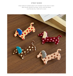 Detail showing four cute polka dot dachshund hair clips on a premium wooden background