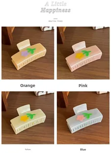 Detailed view of colorful acetate floral hair claws in orange, pink, yellow, and blue