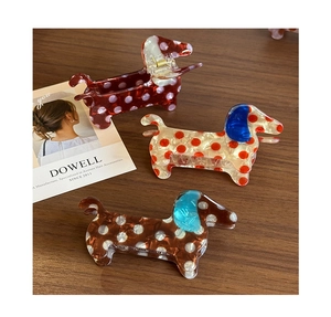 Macro detail of dachshund shaped acetate hair clips with colorful polka dot patterns