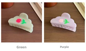 Detail of matte cloud hair claws with tulip patterns in green and purple colors