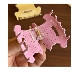Détail de la pince à cheveux cheval à pois rose montrant le ressort et le texte rich