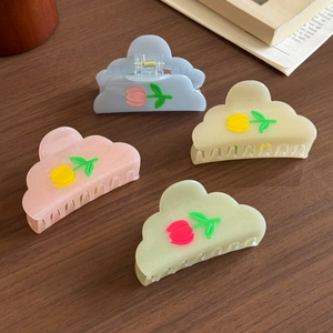 Cute resin flower hair clips set with tulip motifs in pastel colors on wood surface