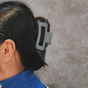 Pince à cheveux rectangulaire grise mate de 8,5 cm portée sur un chignon minimaliste