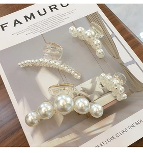 Détail de pinces à cheveux élégantes avec perles de tailles variées sur table en bois