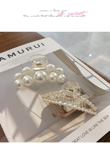 Détail de pinces à cheveux élégantes en perles sur un magazine, design classique en résine