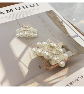 Vue détaillée de deux pinces à cheveux avec perles blanches brillantes sur un magazine