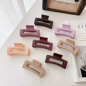 Lot de 8 pinces à cheveux rectangulaires mates aux tons terreux sur un bureau blanc