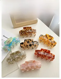 Detail view of large acetate hair claws in multiple retro marble and tortoiseshell patterns