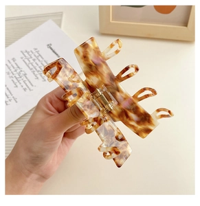 Detail of large tortoiseshell claw clip with gold metal spring and acetate texture