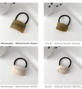 Dettaglio di elastici per capelli geometrici con motivi a venature di legno verde e bianco